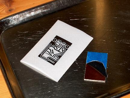 PCB with partly peeled back protective plastic layer and `dried' layout